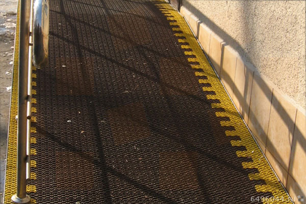 Черное грязезащитное покрытие на ступенях с отделкой по краям.